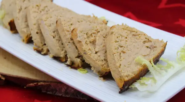 Tranches de pain de thon crème fraîche, garnies de salade, sur une assiette blanche.
