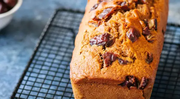 Un délicieux gâteau moelleux aux dattes, tout juste sorti du four et refroidissant sur une grille.