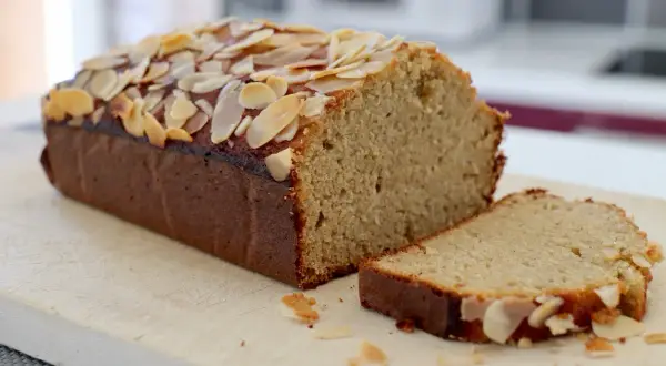 Un délicieux gâteau aux amandes effilées, coupé en part, promettant le meilleur gâteau aux amandes.