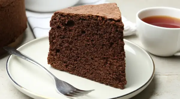 Une part de moelleux gâteau au chocolat, prête à être dégustée avec une tasse de thé. Une recette simple pour un plaisir gourmand.