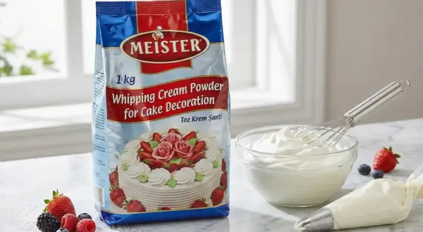 Un paquet de poudre pour crème fouettée Meister, prêt à être transformé en délicieuse crème montée vanille pour décorer des gâteaux. Des fruits frais et une poche à douille complètent la scène.
