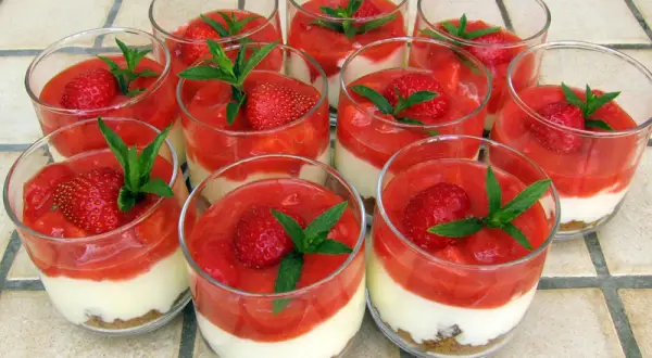 Douze verrines de tiramisu fraise spéculoos, garnies de fruits rouges et de menthe fraîche.