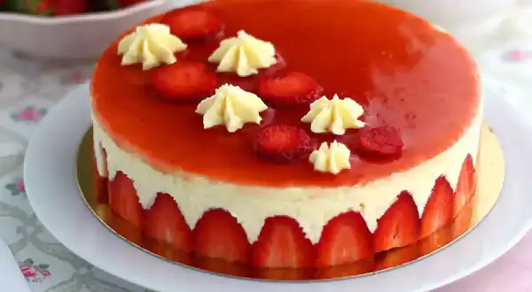 Un magnifique fraisier, parfait pour une recette gourmande. La crème onctueuse est bordée de fraises fraîches, le tout nappé d'un glaçage rouge éclatant.