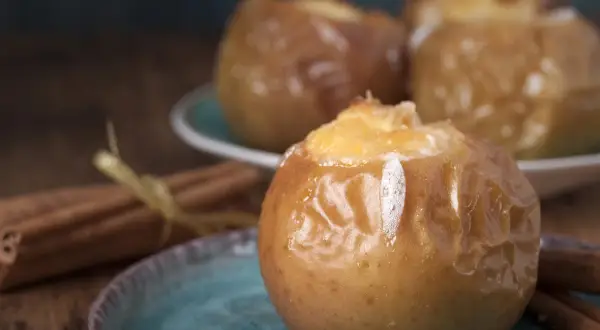 Pommes au four, garnies et dorées, prêtes à déguster. Une recette simple et réconfortante de pomme au four cannelle.