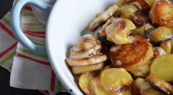 Un plat de truffade de l'Aubrac, pommes de terre fondantes et crémeuses, servi dans un bol blanc.