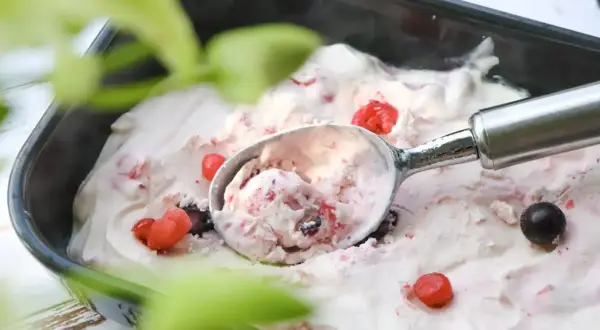 Glace au yaourt grec aux fruits rouges, prête à être dégustée. Une recette simple et rafraîchissante pour l'été.