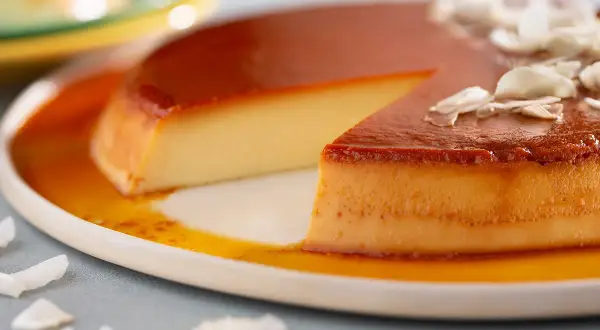 Un flan aux œufs onctueux, nappé de caramel doré et garni de copeaux de noix de coco. Un délice à savourer.