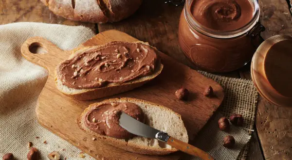 Tartines de pain de campagne généreusement garnies de pâte à tartiner aux noisettes, inspirée par la recette de Cyril Lignac. Un délice gourmand !
