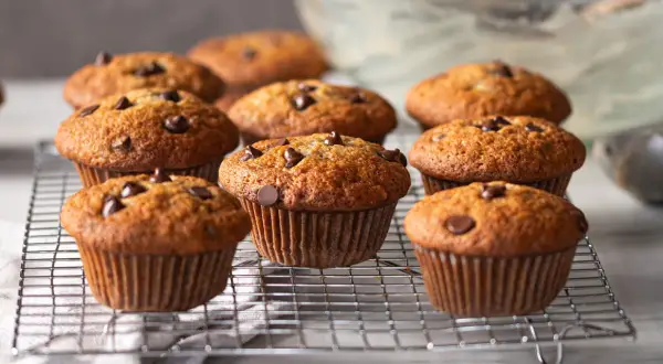 Muffins banane chocolat dorés et moelleux, parsemés de pépites de chocolat, refroidissant sur une grille.