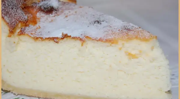 Tranche de tarte au fromage blanc, légère et aérienne, saupoudrée de sucre glace. Un délice crémeux à savourer.