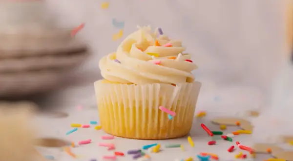 Un cupcake vanille avec glaçage crémeux et vermicelles colorés, parfait pour une recette de cupcake facile et festive.