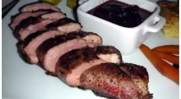 Magret de canard tranché, servi avec une sauce au confit d'oignons. Un délice pour les gourmands.