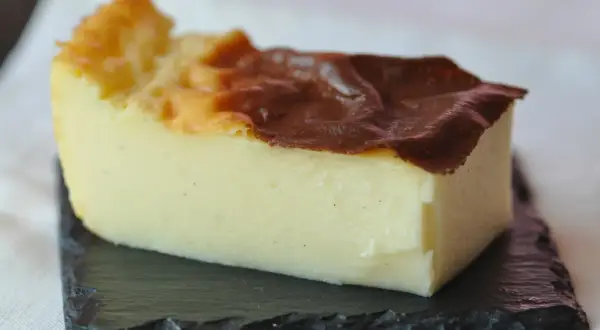 Tranche de flan sans pâte, crémeux et doré, parsemé de points de vanille. Une invitation à découvrir cette recette facile.