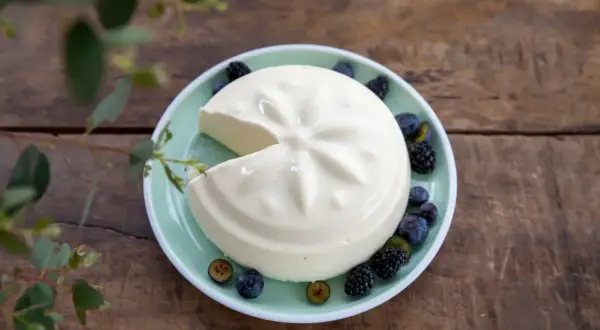 Un blanc-manger crémeux, décoré de baies, évoque la vraie recette du blanc-manger.