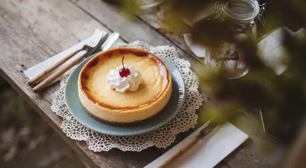 Un délicieux cheesecake, prêt à être dégusté, avec une cerise sur le dessus. Une invitation à essayer cette recette !