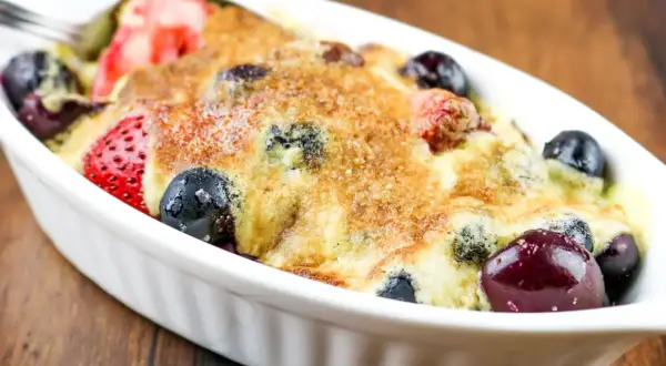 Un délicieux sabayon aux fruits rouges, fraises et myrtilles, gratiné et prêt à être dégusté.