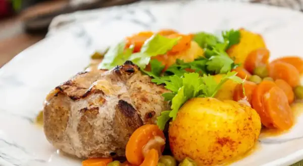 Paupiette de veau savoureuse, accompagnée de pommes de terre rôties, carottes et petits pois. Un plat réconfortant pour la cuisson.