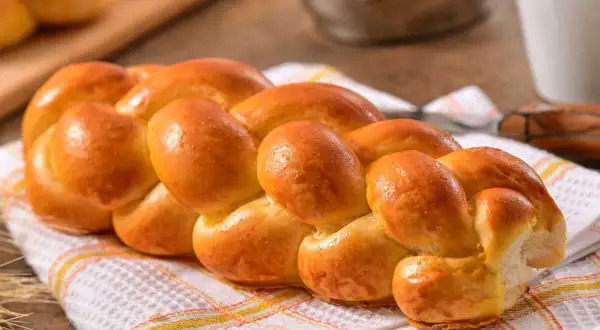 Une belle brioche tressée dorée, parfaite pour une recette de brioche facile à la main. Idéale pour le petit-déjeuner ou le goûter.