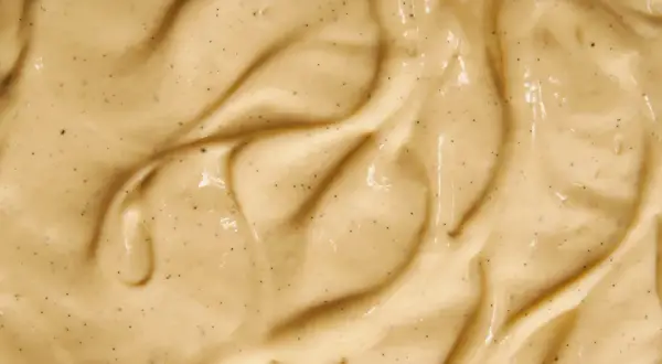 Texture onctueuse de crème pâtissière à la vanille, parsemée de petits points noirs de vanille.