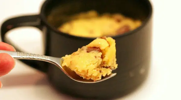 Une cuillère de mug cake cookie, moelleux et gourmand, prêt à être dégusté.