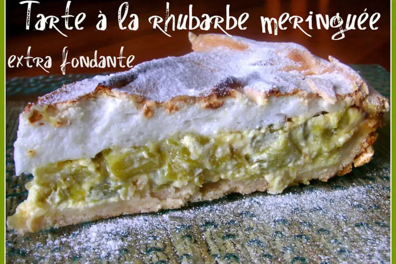 Une généreuse part de tarte rhubarbe alsacienne, extra fondante, avec sa meringue dorée et saupoudrée de sucre glace.