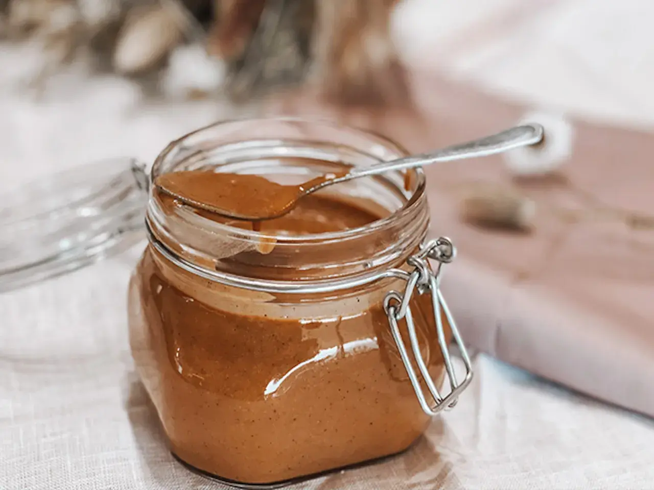Un pot de praliné noisette maison, prêt à être dégusté. Une recette simple pour un délice gourmand.