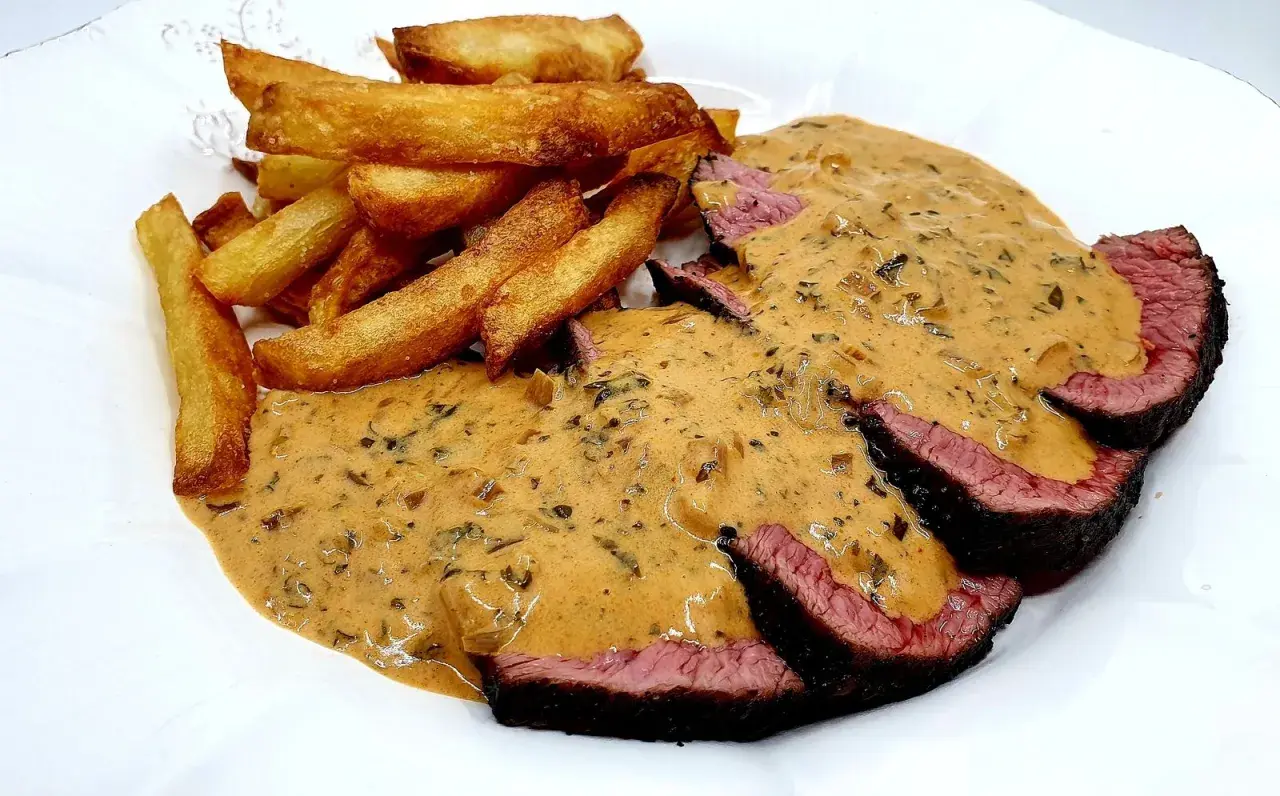 Tranches de bœuf saignant nappées d'une sauce crémeuse, accompagnées de frites dorées. Un délice avec cette sauce viande rouge.