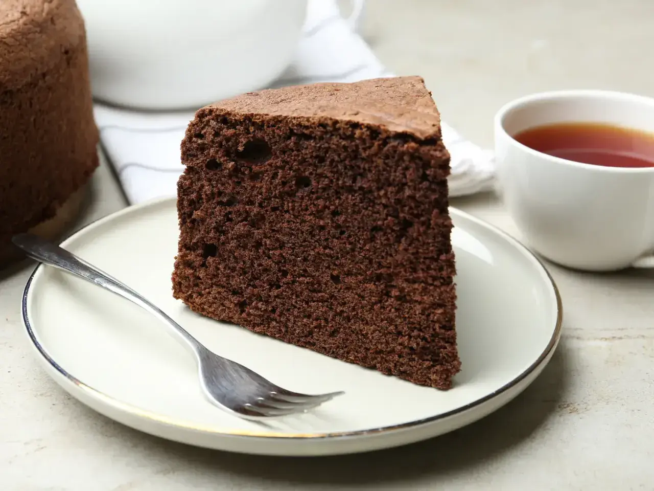 Une part de moelleux gâteau au chocolat, prête à être dégustée avec une tasse de thé. Une recette simple pour un plaisir gourmand.