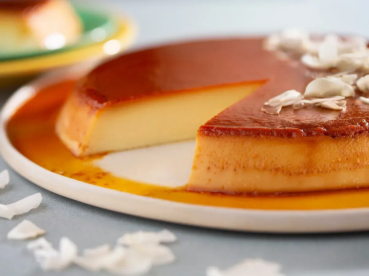 Un flan aux œufs onctueux, nappé de caramel doré et garni de copeaux de noix de coco. Un délice à savourer.