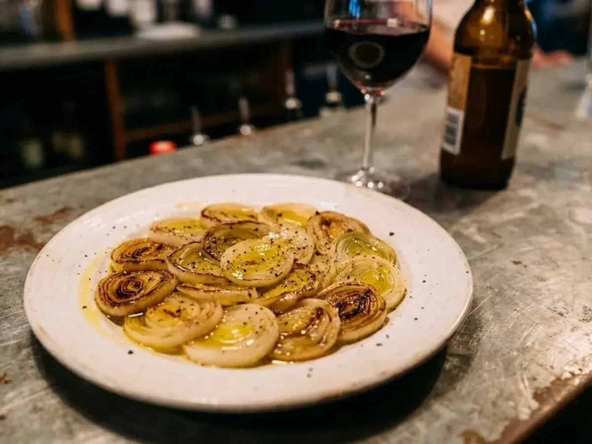 Poireaux vinaigrette, tendres et caramélisés, accompagnés d'un verre de vin rouge et d'une bière. Un délice simple.