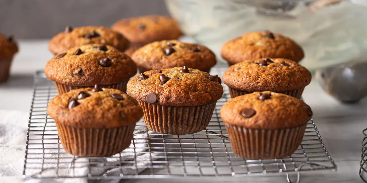 Muffins banane chocolat dorés et moelleux, parsemés de pépites de chocolat, refroidissant sur une grille.