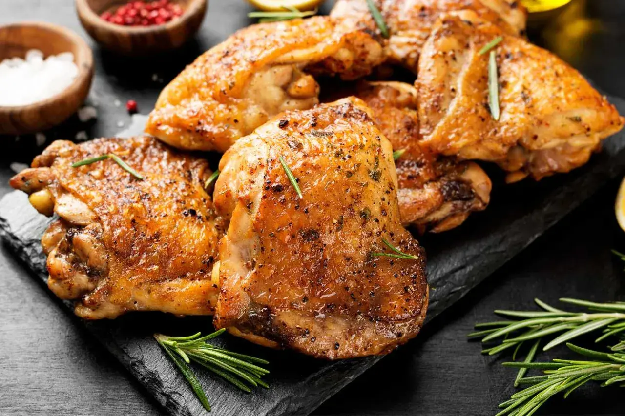 Cuisses de poulet dorées et croustillantes, assaisonnées d'herbes, prêtes à être dégustées. Un délice cuisiné au Cookeo.