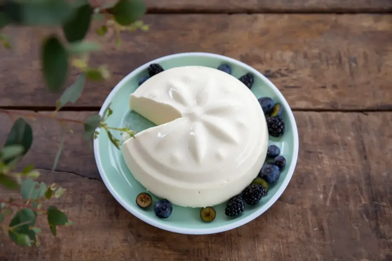 Un blanc-manger crémeux, décoré de baies, évoque la vraie recette du blanc-manger.