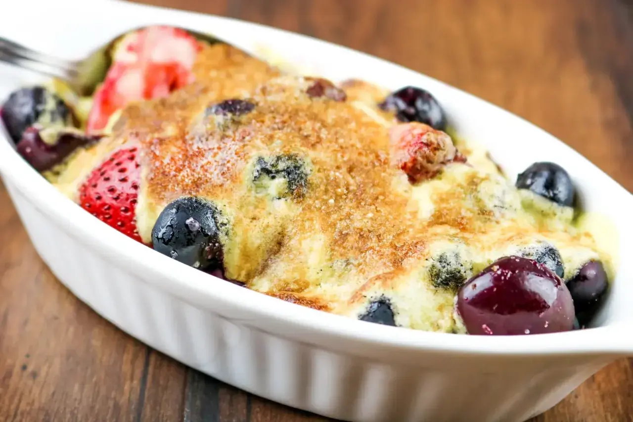 Un délicieux sabayon aux fruits rouges, fraises et myrtilles, gratiné et prêt à être dégusté.