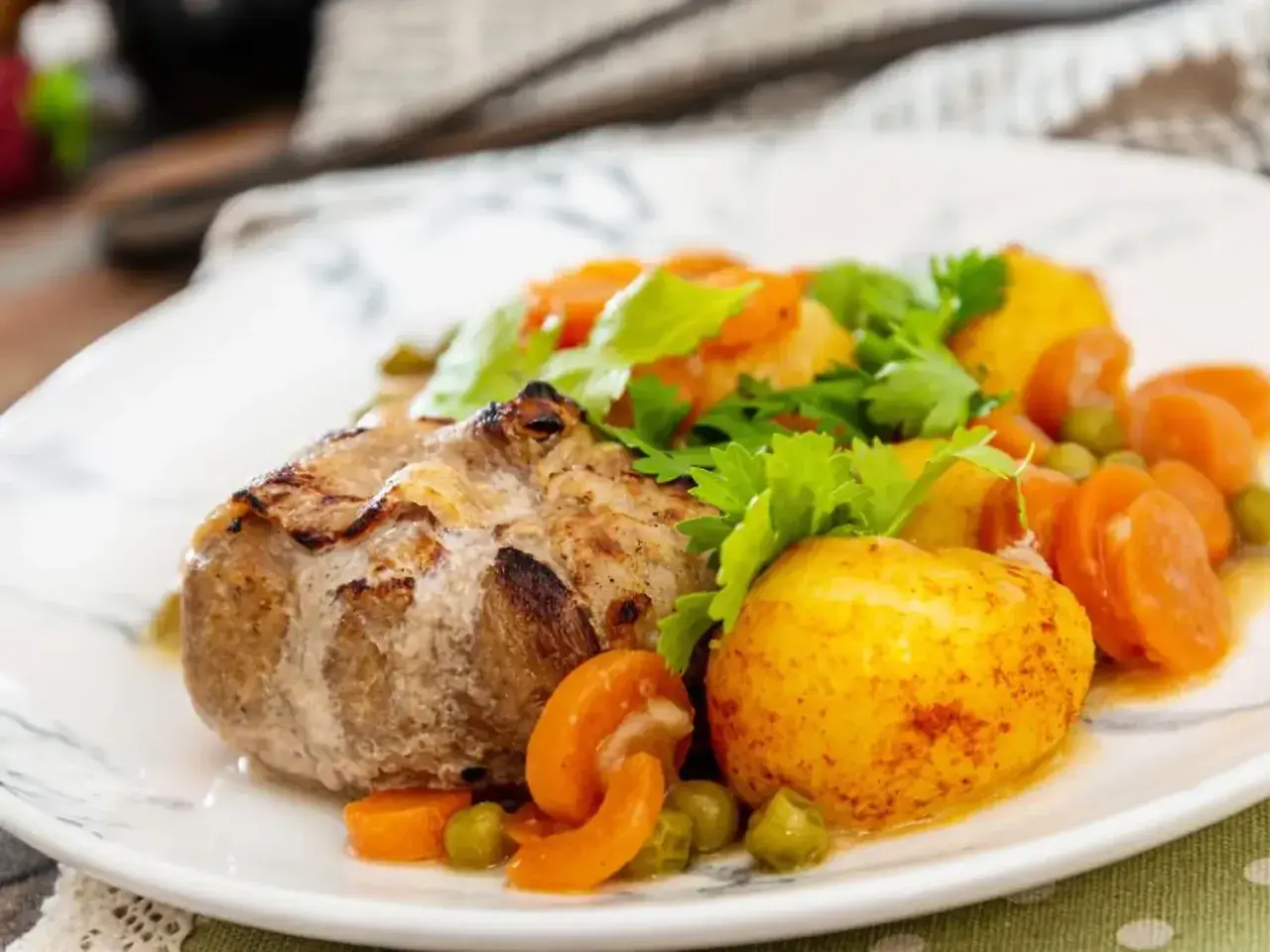 Paupiette de veau savoureuse, accompagnée de pommes de terre rôties, carottes et petits pois. Un plat réconfortant pour la cuisson.