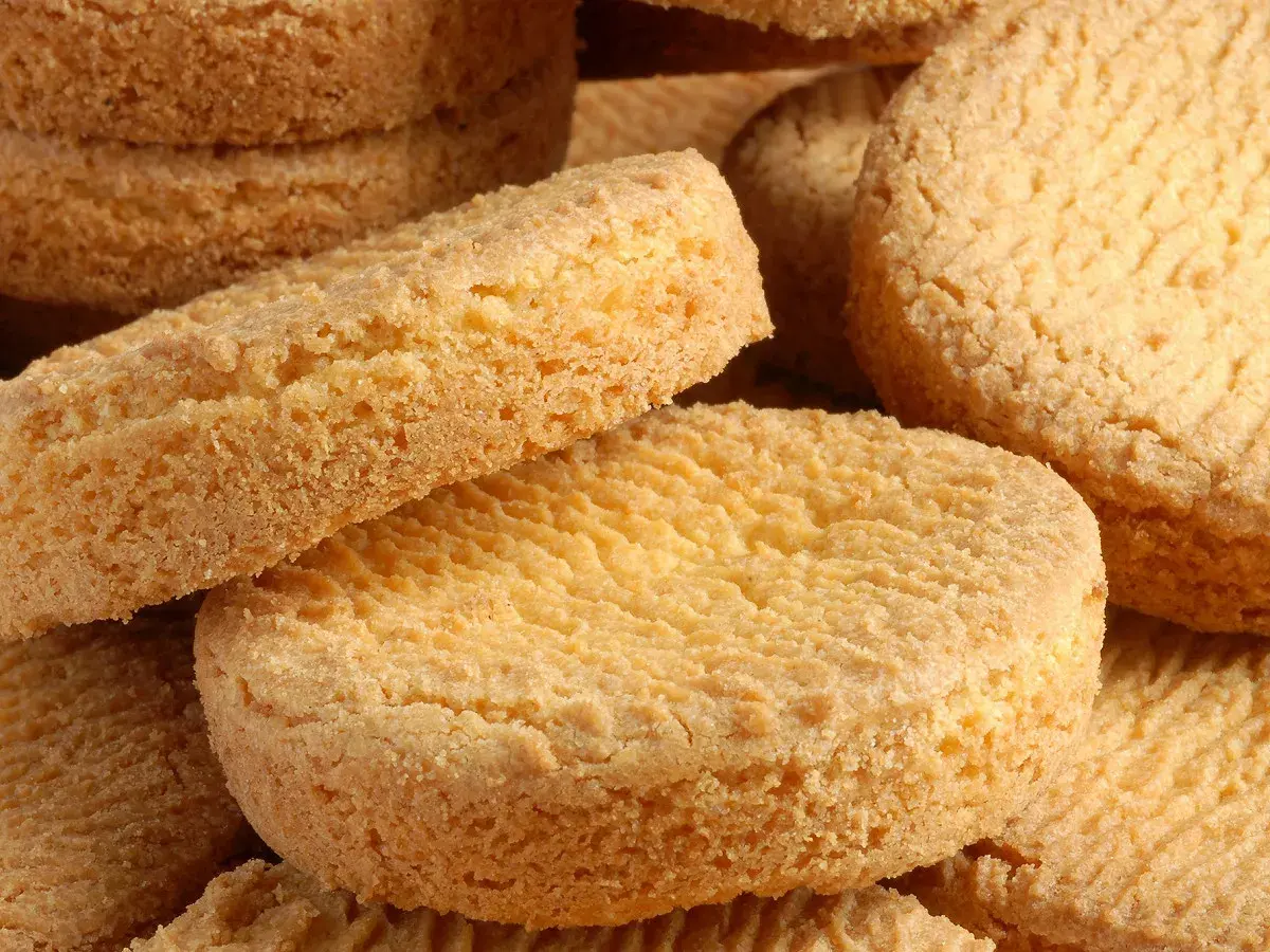 Gros plan sur une pile de palets bretons dorés, leur texture granuleuse appétissante.