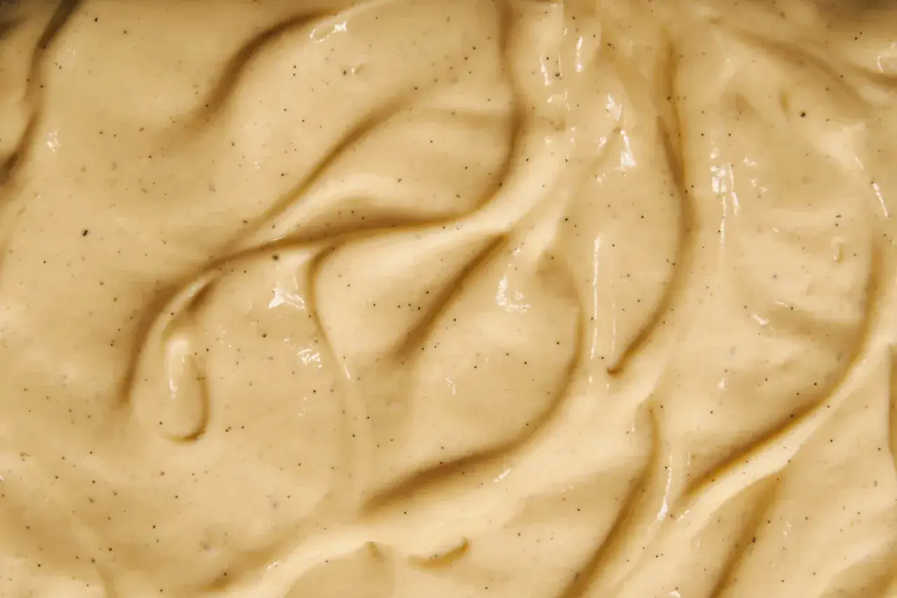 Texture onctueuse de crème pâtissière à la vanille, parsemée de petits points noirs de vanille.