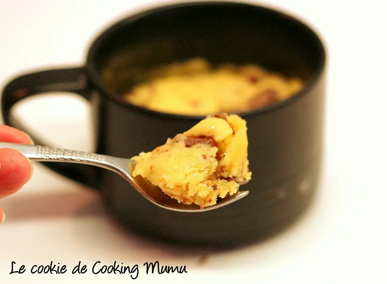 Une cuillère de mug cake cookie, moelleux et gourmand, prêt à être dégusté.
