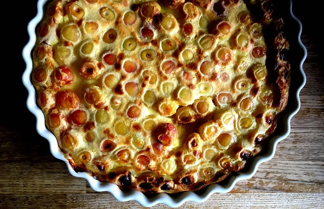 Clafoutis aux cerises doré et appétissant, prêt à être dégusté. Une recette simple pour un dessert fruité.