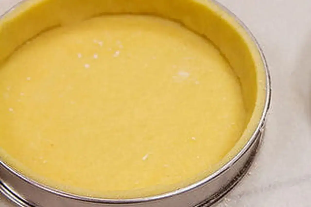 Pâte sablée dorée, prête à être garnie dans son cercle à tarte. Un délice en devenir.