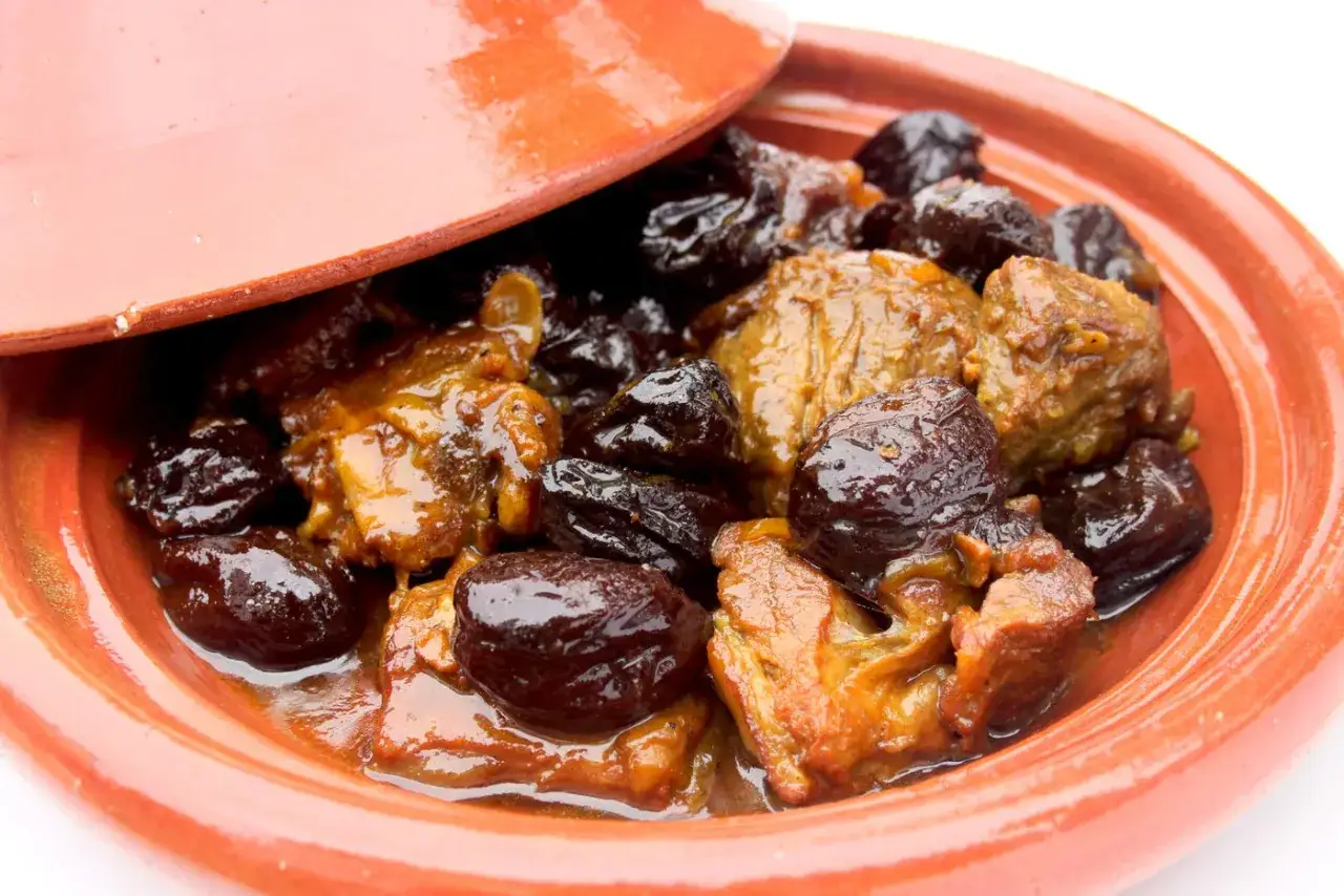 Un d&eacute;licieux tajine agneau aux pruneaux, mijot&eacute; dans sa sauce onctueuse, servi dans un plat en terre cuite.