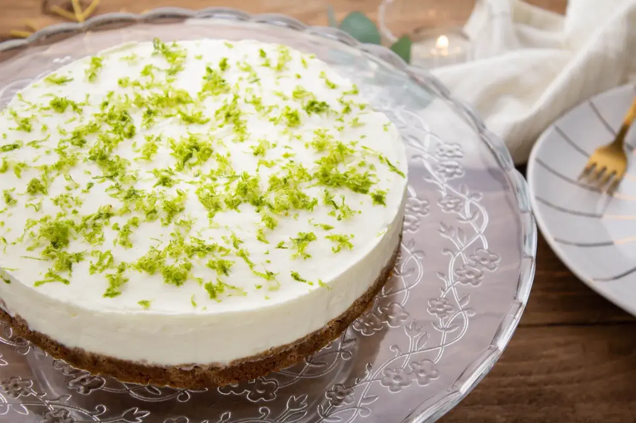 Cheesecake citron mascarpone, frais et léger, garni de zestes verts vifs. Parfait pour une recette d'été.