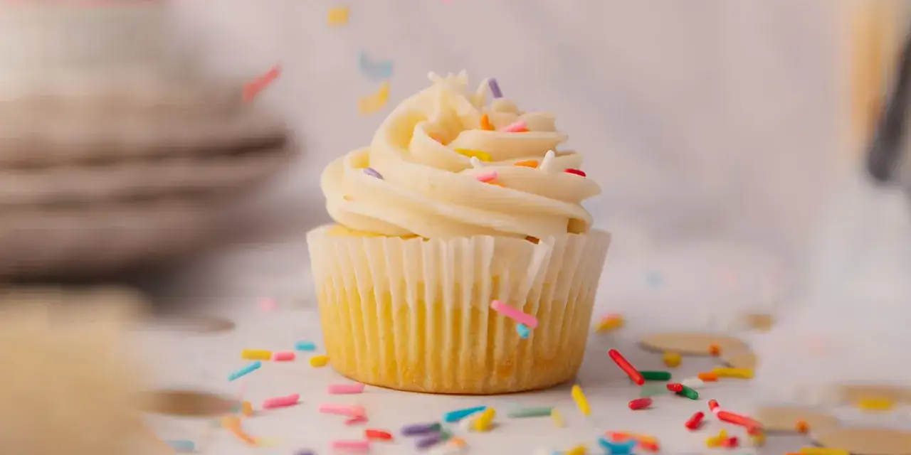 Un cupcake vanille avec glaçage crémeux et vermicelles colorés, parfait pour une recette facile.