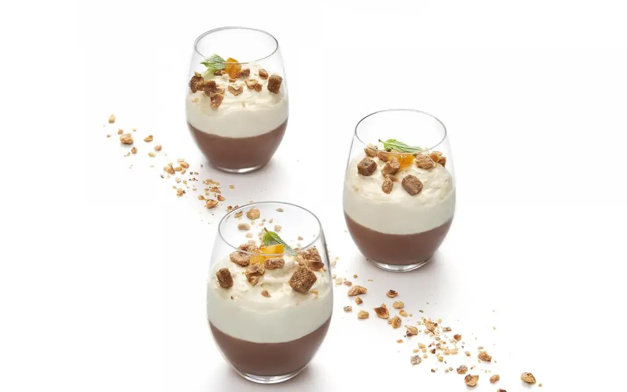 Trois verrines de cr&egrave;me au chocolat et chantilly, garnies de noisettes concass&eacute;es et d'une touche de menthe. Une recette cr&egrave;me au chocolat grand chef.