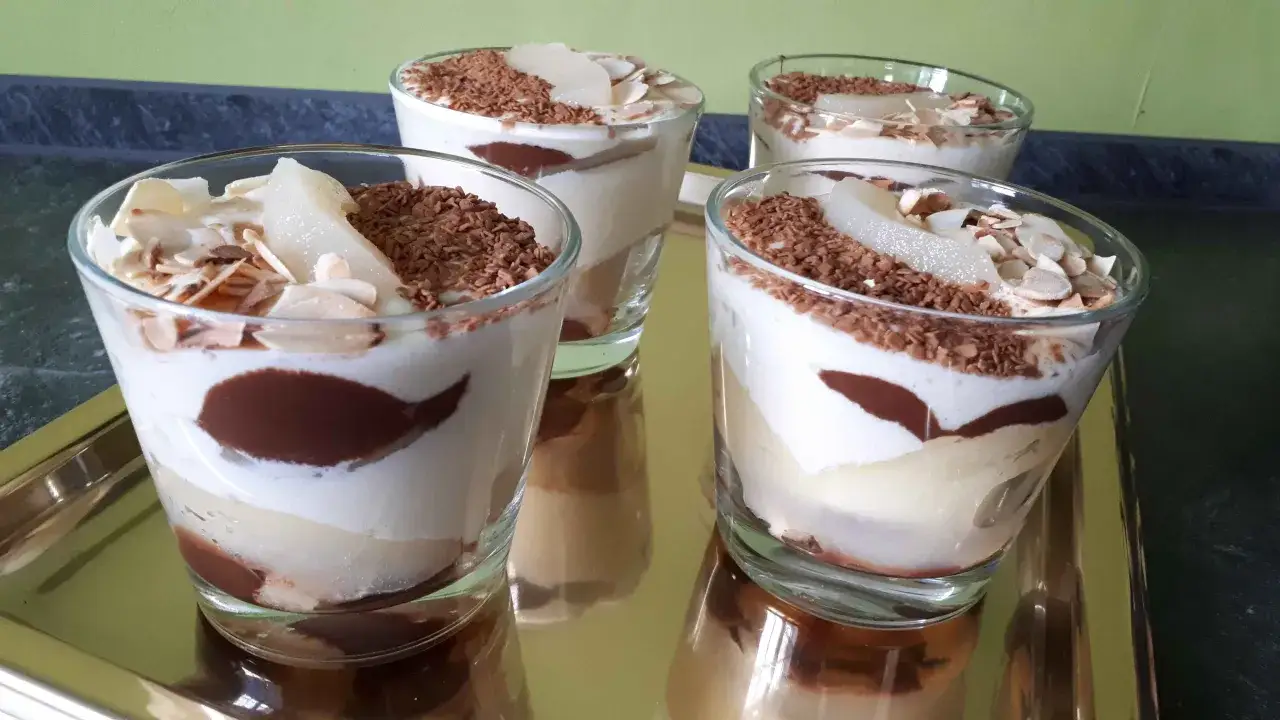 Quatre verrines de tiramisu chocolat, poire et amandes effilées, un délice gourmand.