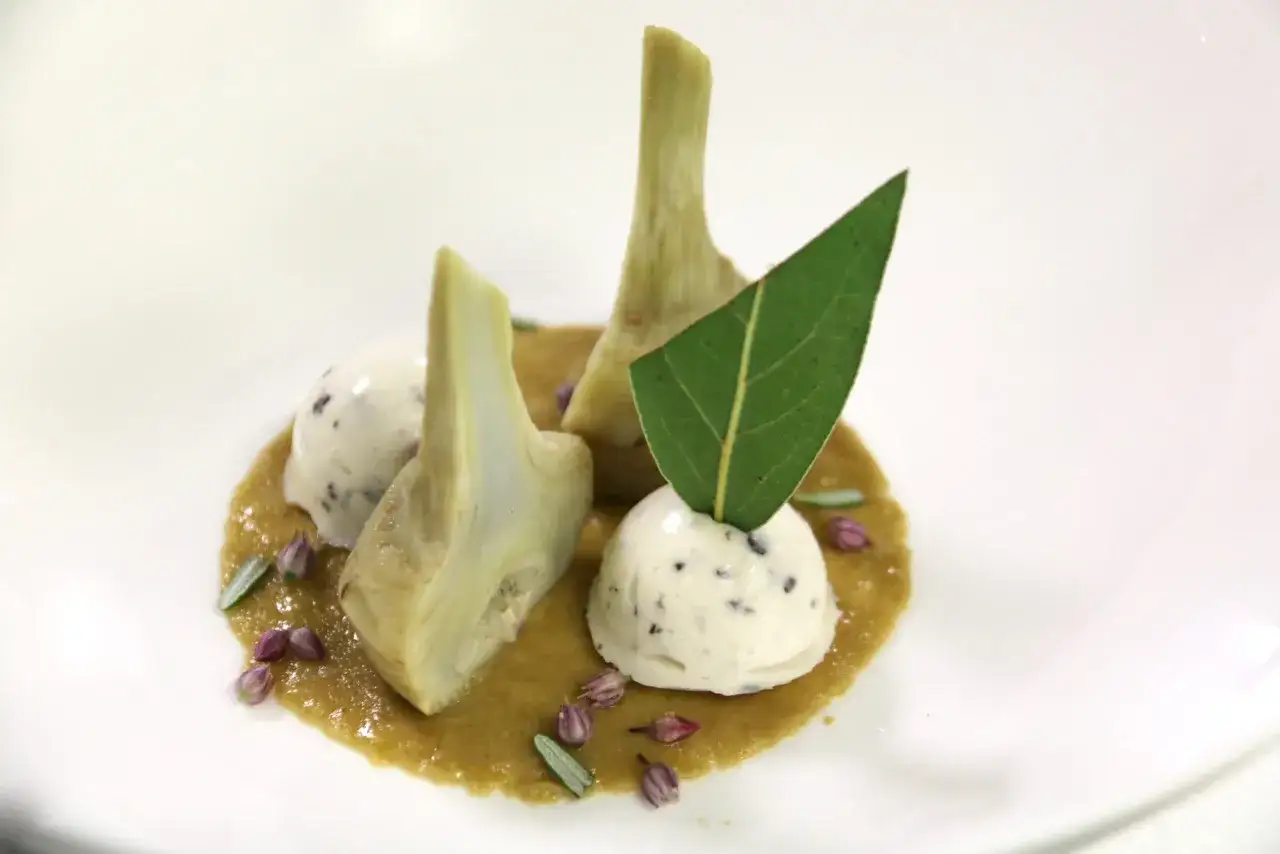 Artichaut barigoule etchebest : cœurs d'artichauts tendres, glace au poivre noir, sauce légère et herbes fraîches. Une création audacieuse.