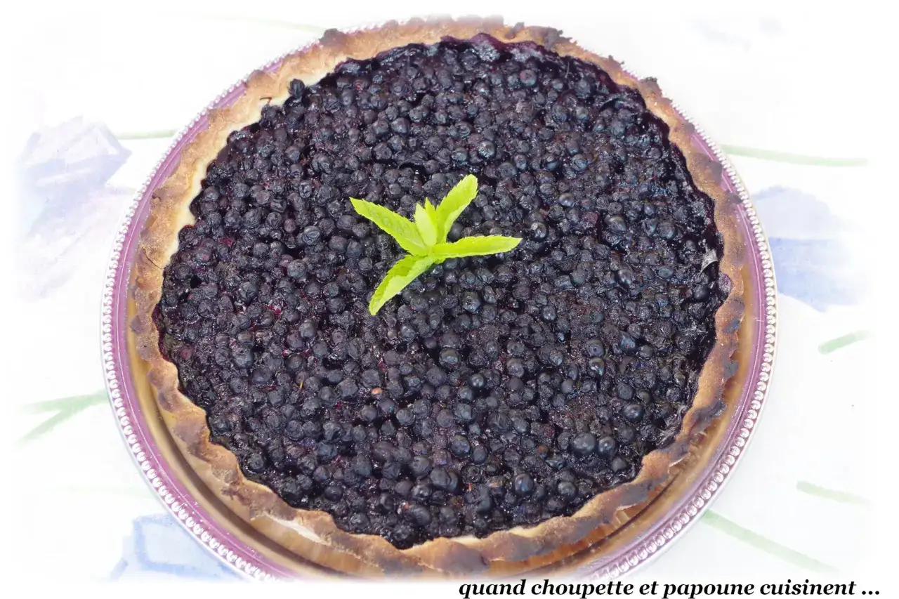 Tarte aux myrtilles généreuse, garnie de fruits frais et d'une touche de menthe. Un délice fait maison.