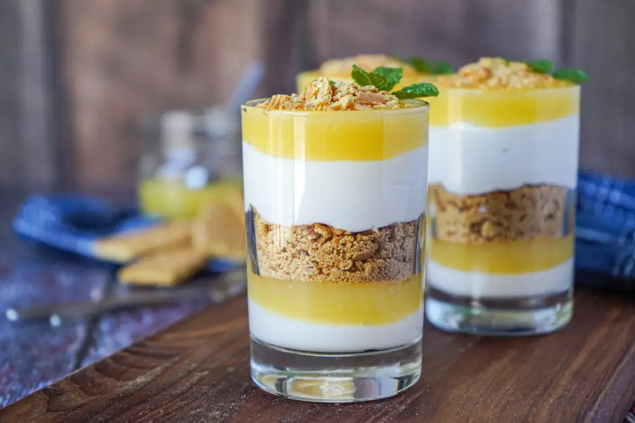 Desserts en verrines : couches de biscuit émietté, crème blanche et un délicieux lemon curd, garnies de menthe.