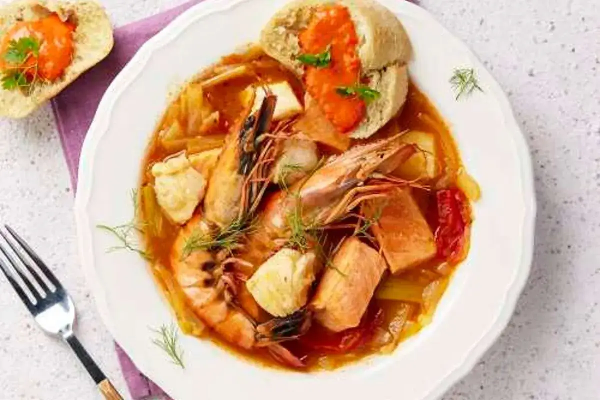 Une assiette de rouille, recette traditionnelle, avec crevettes, poisson et pain garni.