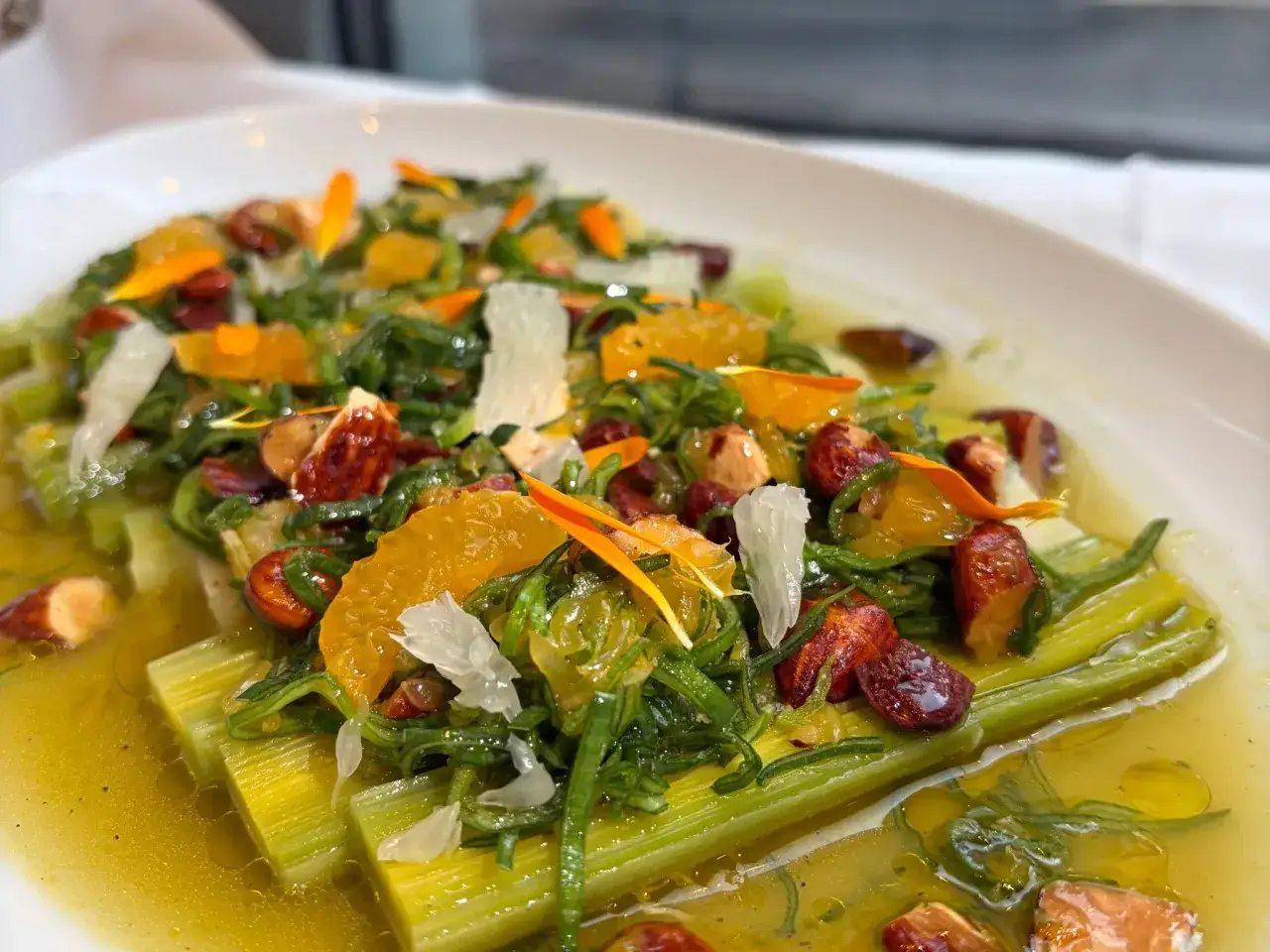 Poireaux vinaigrette, un plat color&eacute; avec des poireaux tendres, des agrumes, des noix et des &eacute;clats de fromage.